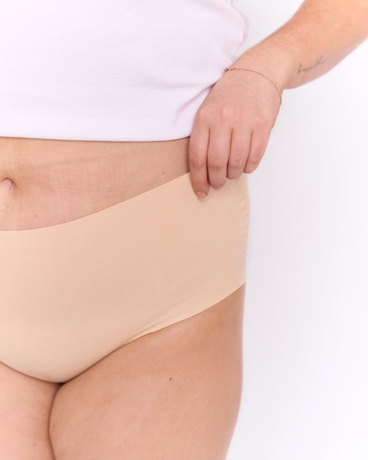 Close up view of a woman wearing a white t-shirt, showcasing Trelou's active underwear line.